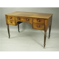 A George IV mahogany writing table, with five drawers, on turned and reeded legs, 122cm wide x...