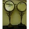 Image 1 : A Pair of Brass Mirrors, the circular plate on a figural column standing on a black marble plinth...