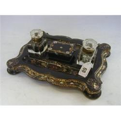 A JENNENS & BETTRIDGE PAPIER MACHE DESK STAND, mid 19th Century, cartouche shape, bun feet, gilt...