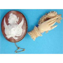 A Victorian carved ivory brooch in the form of a hand holding a flower spray, together with a Vic...