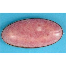 A Ruskin pink glazed pottery brooch in plain silver frame, 1.75ins....
