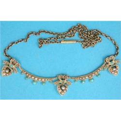 An Edwardian gold swag necklace with three heart shape drops each with a tied ribbon surmount, se...