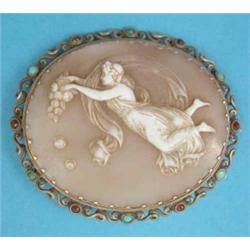 A Victorian shell cameo brooch carved with a muse, in scroll work frame set turquoises, 2.25ins....