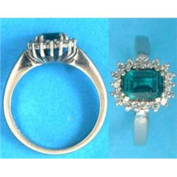 An 18ct white gold ring, set with a rectangular cut synthetic emerald and white stones...