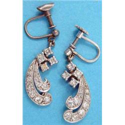 A pair of diamond set scroll design white metal drop earrings....