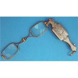 A Continental silver gilt lorgnette with foliate chased handle....
