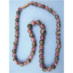 A single row necklace of graduated polished agate and amethyst beads, 18 ins....
