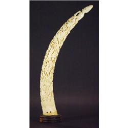 Large ivory tusk, heavily carved with figur…