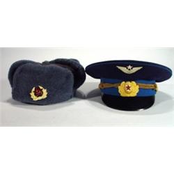Two Russian military hats with badges…