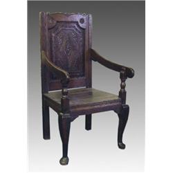 A late 17th Century oak wainscote chair, the slightly wavy top rail with rosette carving above a...