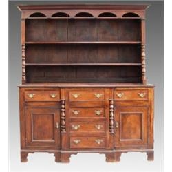 An oak and mahogany Welsh dresser, early 19th Century, the moulded cornice above an enclosed plat...