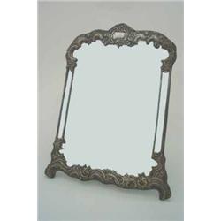 A William Collins silver mirror, with ornate frame in the rococo style with scroll-embossed flowe...