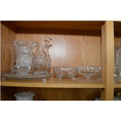 Shelf lot containing a large selection of cut and pressed crystal including pitchers, vases, dishes
