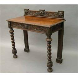 An Edwards & Roberts oak hall table, carved with masks and arabesques, with galleried back and fi...