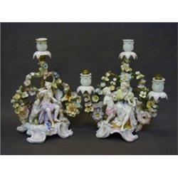 A PAIR OF CANDELABRA, late 19th Century, hard paste porcelain, female figure surrounded by bocage...