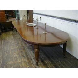 A MAHOGANY WIND-OUT DINING TABLE, 19th Century, oval ends, five leaves, fluted capitals and taper...