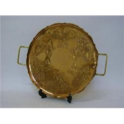 A CIRCULAR COPPER TRAY, stylized Art Nouveau tendril design, twin brass handles, ball feet, maker...