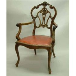 An Edwardian walnut elbow chair, with foliate scroll carved frame and cabriole legs...
