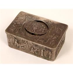A 19th Century Bird Music Box, decorated villages scenes in relief, in a silver coloured metal ca...