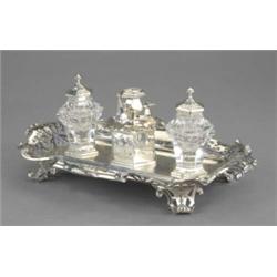 A Victorian inkstand, in 'Jacobethan' style, of shaped outline with paper scroll mouldings, the s...