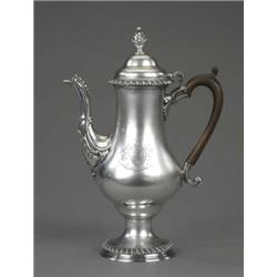 A George III gadrooned baluster coffee pot, the domed lid with bud finial, scroll and bead-cast s...