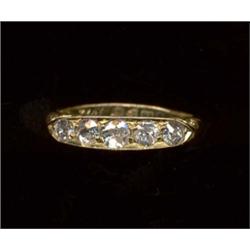 An 18ct gold five-stone diamond ring, the graduated old cut stones set within a carved half hoop...