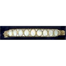 An opal and diamond hinged bangle, in 19th century style, comprising row of nine oval cabochon op...