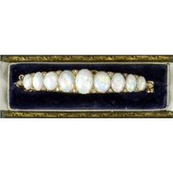 An opal and diamond hinged bangle, c.1890, the nine graduated opals each interspersed with eight...