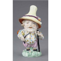 A Derby figure of a Mansion House dwarf, wearing gilt star and turquoise jacket, pink breeches an...