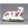 Image 1 : A creamware figure of a resting sheep, sponged in brown and on a green base, 5.5in wide, early 19...