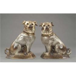 A pair of Victorian figures of seated pugs, with shaded grey glaze and glass eyes, 11.75in high...