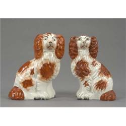 A small pair of Staffordshire figures of seated spaniels, with brown splashed coats, well detaile...
