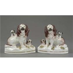 A good pair of Samuel Alcock porcelainous figures of seated King Charles spaniels, each with a pu...