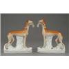 Image 1 : A pair of Staffordshire figures of standing greyhounds, with shaded tan coats, each with a hare i...