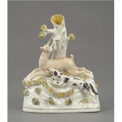 A Staffordshire tree stump vase group of a black spotted hound pursuing a stag, shredded clay enc...