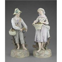 A pair of French coloured biscuit figures of fruit vendors, in flowered 18th century costumes, on...