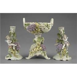 A German pierced dessert stand, encrusted with flowers, on tripod feet, painted in pastel colours...