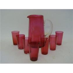A RUBY GLASS WATER JUG, clear loop handle, with seven matching beakers (8)  50-80...