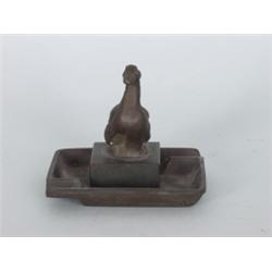 Varia : Aschenbecher. Bronze. In rechteckiger Schale vollplastische Ente auf quadrat- schem Podest. 