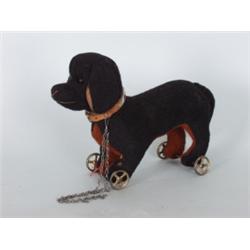 Varia : Stofftier. Dackel auf Räder. Schwarz-brauner Filz, Glasaugen, Halsband aus Leder. Marke Herm