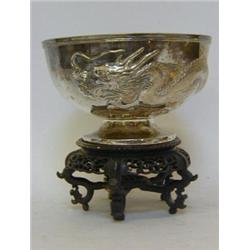 AN ORIENTAL WHITE METAL ROSE BOWL, early 20th Century, embossed with encircling coiled dragon, ma...