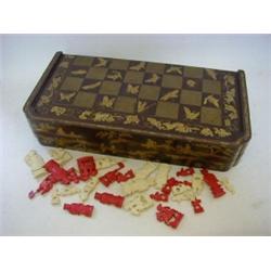 AN ORIENTAL CHESS AND BACKGAMMON BOX, maroon and gold laquer, hare, butterfly, and spider decorat...