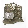 Image 1 : A Victorian brass and glass inkwell, the swirled moulded glass well in a pierced frame with stati...