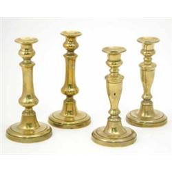 Two pairs of George IV brass candlesticks, each with push-eject and circular base, 8.5 ins....