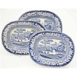 A graduated set of three Victorian blue and white serving plates, printed with a river scene and...