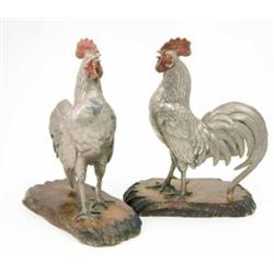 A pair of early 20th century Japanese painted white metal cockerels, each standing on a wooden ba...