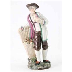 A Niderviller figure of an apple vendor in brown hat, puce-lined white coat, brown breeches and b...