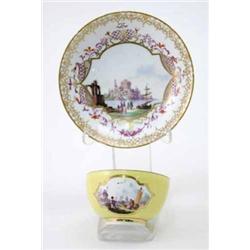 A Meissen yellow-ground teabowl painted with merchants in river landscapes within shaped quatrefo...