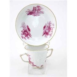 A Meissen two-handled beaker and saucer painted en camaieu rose with lovers in landscape vignette...