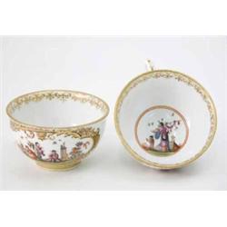 A pair of Meissen teacups probably painted by Metzsch with panels of chinoiserie figures at vario...